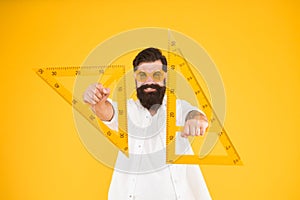 For drawing, draughting and design. Hipster holding drawing instruments on yellow background. Architect and engineer photo