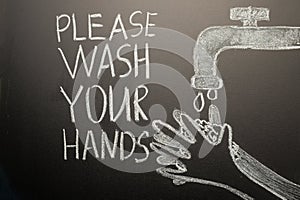 Drawing of a hand wash on the blackboard with chalk and the inscription -Please wash your hands. Coronavirus, precautions