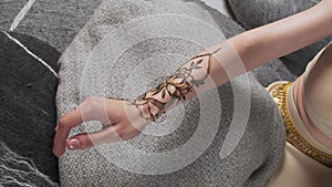 Drawing Mehndi henna tattoo. Process of applying mehndi on female hands. Henna painting
