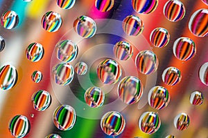 Drawing pencils reflected on waterdrops resting a piece of glass