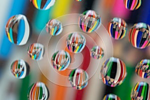 Drawing pencils reflected on waterdrops resting a piece of glass