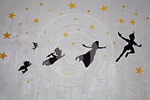 Drawing of Peter, Wendy, John, Michael and Tinker Bell on a wall with golden stars