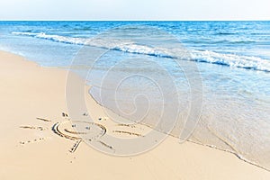 The drawing of the sun on sand beach with soft waves