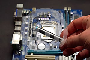 Drawing thermal paste on computer processor. Installing a cooling system on a CPU processor