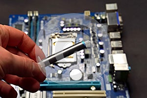 Drawing thermal paste on computer processor. Installing a cooling system on a CPU processor
