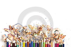 Drawing tools background. Lot of colorful pencils frame with sawdust and shavings on white