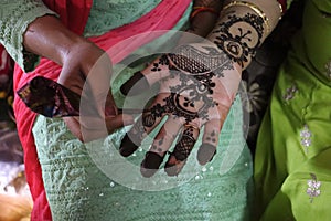 Drawing traditional tattoo on hands- Mehndi.