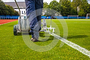 drawing of a white line on the green lawn of a football stadium