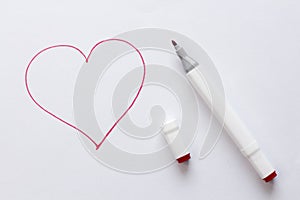 Drawn by a bright red felt-tip pen or marker a red heart on white paper and a white background. Love, romance, valentines day.