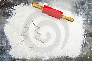 Drawn Christmas tree on flour scattered. Silhouette of Christmas tree made of flour, dark background