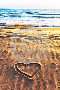 Drawn heart shape on sea sand beach