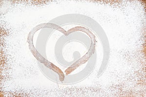 Drawn heart on a table strewn with flour.