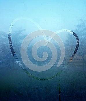 Drawn heart on the wet glass