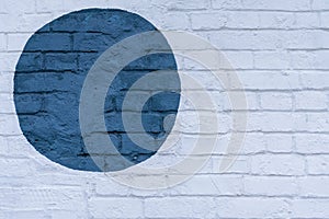 Drawn painted blue circle on a light brick wall bricks surface of wall, as graffiti. Graphic abstract modern background