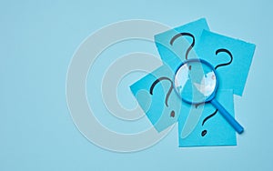 Drawn question marks on stickers and a magnifying glass, blue background