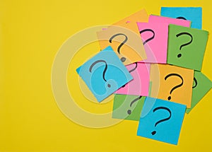Drawn question marks on stickers, yellow background. Searching for truth