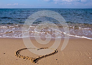 Drawn in the sand heart on the sea