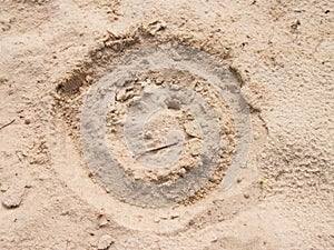 Drawn smiley face in summer beach sand. Painted head in dray salt sand.