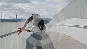 Dreadlocks man dancing bridge closeup. Sensual guy touching fence looking camera