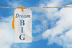 Dream Big message white gift tag over sky