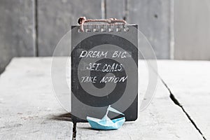 Dream big, set goals, take action on blackboard written