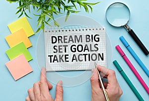 Dream Big Set Goals Take Action text quote on notepad, concept background