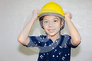 Dream careers concept, Portrait of Happy engineer kid in hard hat looking at camera on blurred background