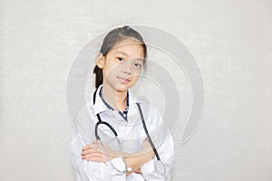 Dream careers concept, Portrait of Happy kid in doctor coat with stethoscope blurred background