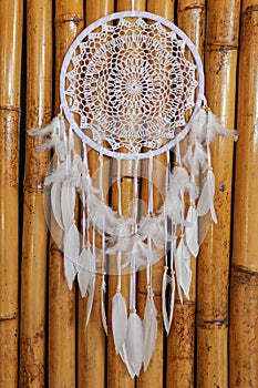 Dream catcher, decorated with white feathers and wooden beads, o