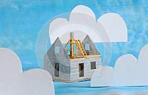 the dream of home ownership, model house under construction and clouds, conceptual image, shallow depth of field photo