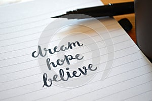 DREAM HOPE BELIEVE hand-lettered in notebook