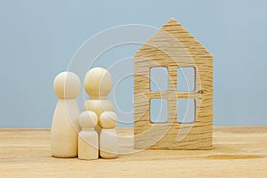 Dream house Concept, Wooden figures, Happy family with children standing in front of their own home, Housing concept