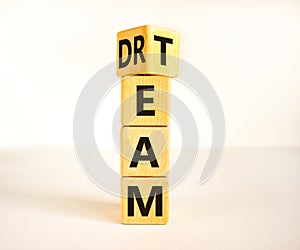 Dream team dreamteam symbol. Turned a wooden cube and changed the word Dream to Team. Beautiful white table white background.