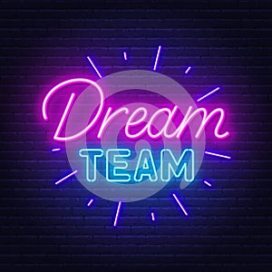 Dream Team neon sign on brick wall background.