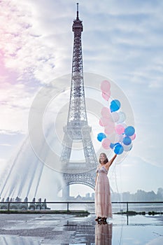 Dream travel - young woman with balloons walking near Eiffel Tower in Paris