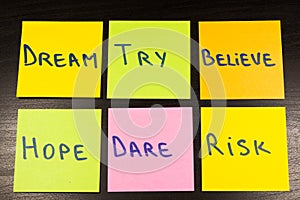 Dream try believe hope dare risk sticky note on wooden background