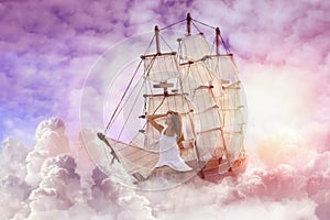 Dream world. Sailing ship with beautiful girl on board floating among wonderful fluffy clouds