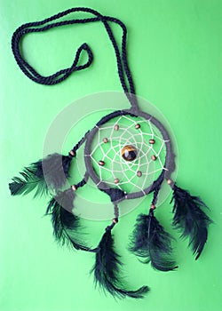 Dreamcatcher of feathers on a green background. Indian talisman. Big Dream Catcher.