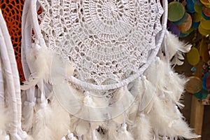 Dreamcatcher with feathers, white tribal symbol.
