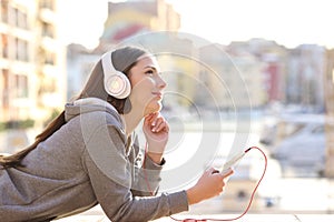 Dreamer girl listening to music on vacation photo