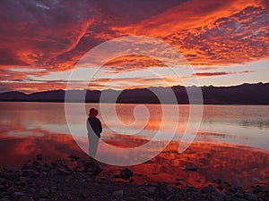 Dreamer, silhouette of woman standing along the lake at sunset, human strength, psychology concept