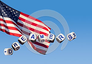 Dreamers concept using spelling letters against blue sky and flag