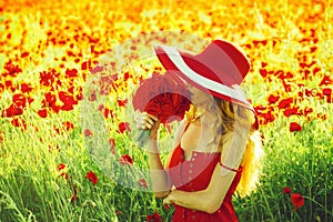 Dreaminess. beautiful girl with hat in red poppy field