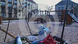 Dreaming adult woman swinging in hanging seat, relaxing on vacation, memories