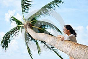 Dreaming beautiful woman relax on tropical beach with palm tree