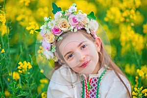 Dreaming Beautiful young girl with flower chaplet, ethnic folklore dress with traditional Bulgarian embroidery during sunset on a