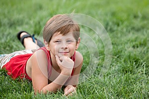 Dreaming boy on the green grass