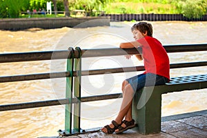 Dreaming boy looking at the river
