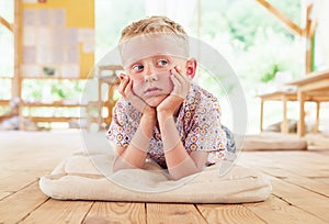 Dreaming boy lying on summer terrace