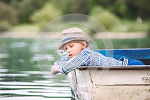 Dreaming boy in old boat on the summer boat